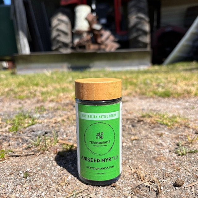 A glass Jar of Aniseed Myrtle in front of a tractor