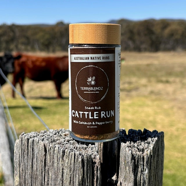 Cattle Run Steak Rub (with Saltbush & Pepperberry) on a fence post with a cow in the background.